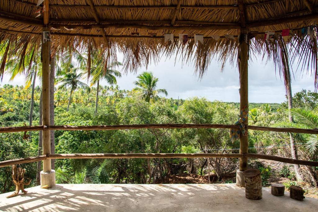 uma vista do alpendre de uma cabana com árvores em Vila Flor Eco Centro em Diogo