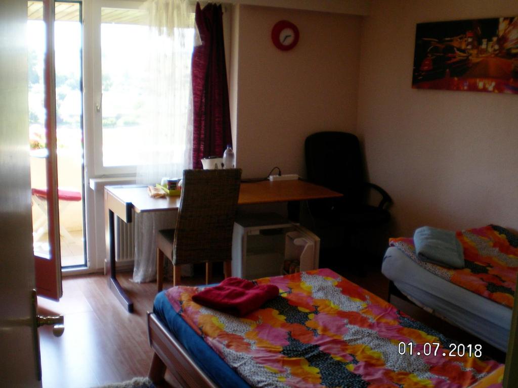1 dormitorio con cama, escritorio y mesa en Visavis en Gondiswil