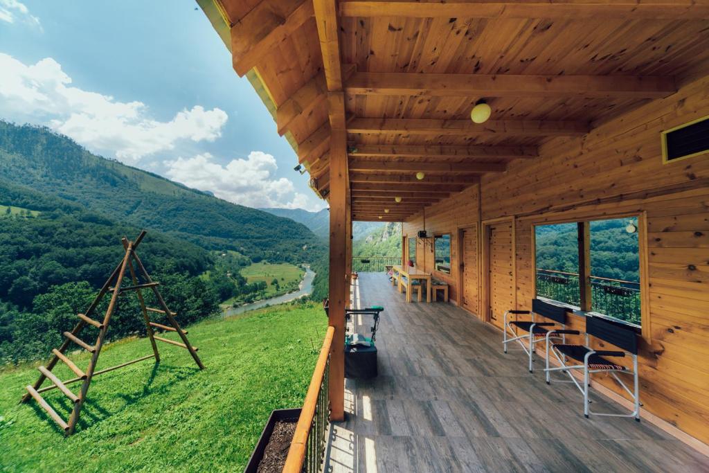 une cabine avec une terrasse offrant une vue sur les montagnes dans l'établissement Chalet Tara, à Mojkovac