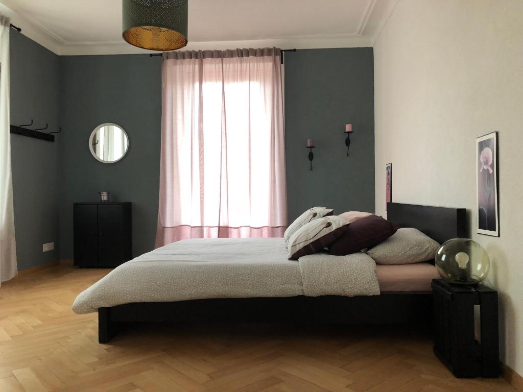 1 dormitorio con cama y ventana en Appartement Douces heures avec parking couvert privé en Le Locle