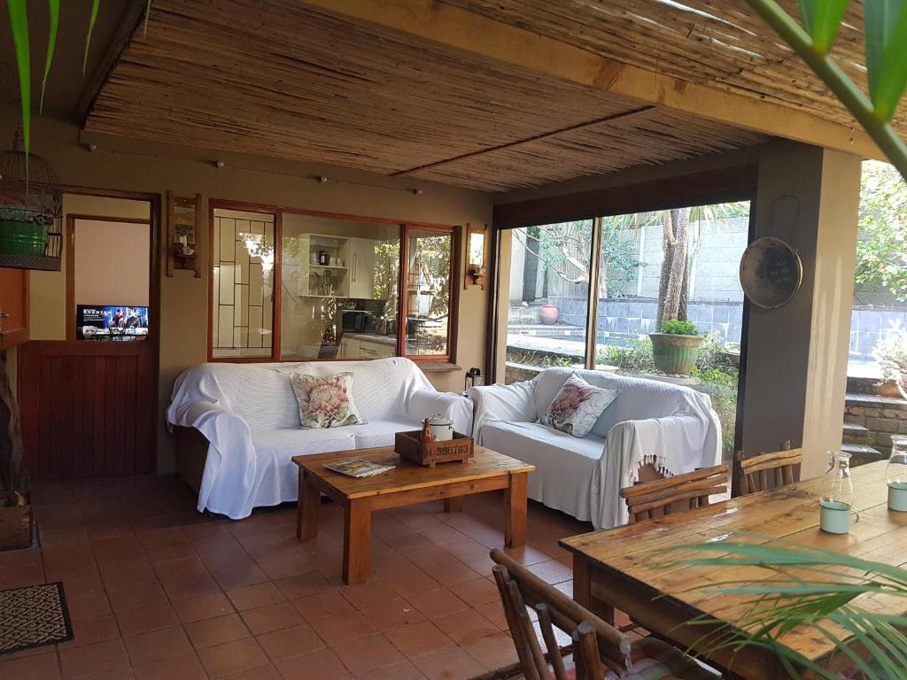 a living room with two white couches and a table at Protea Cottage in George