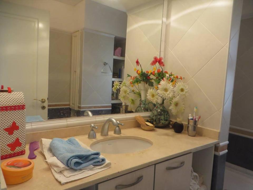 a bathroom with a sink and a mirror and flowers at Barrancas Del Golfo in Puerto Madryn
