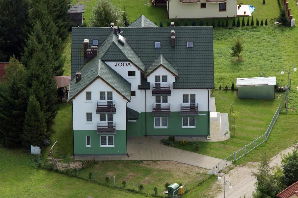 a large white house with a black roof at JODA Pokoje Goscinne in Rewal