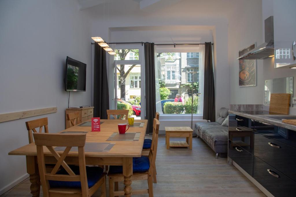 Pandoras home في برلين: مطبخ وغرفة معيشة مع طاولة وأريكة