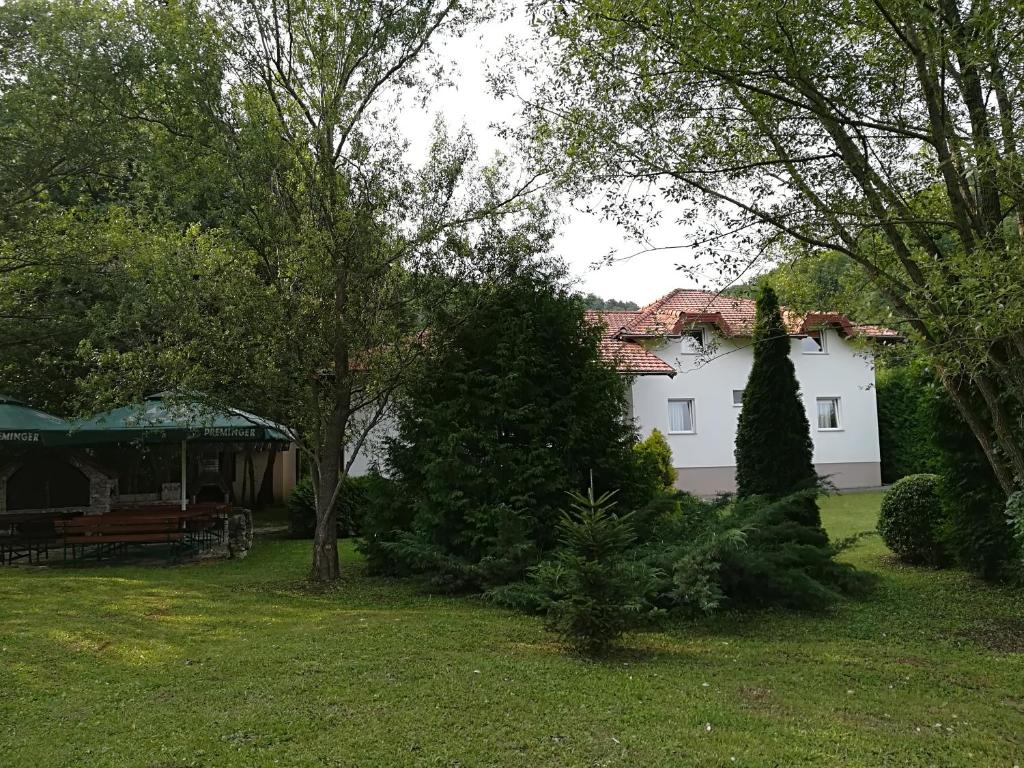 ein weißes Haus mit Bäumen im Hof in der Unterkunft Villa Nana in Kulen Vakuf