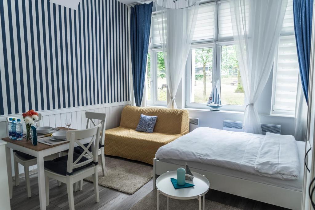 a bedroom with a bed and a table and a chair at Marina House Apartments in Międzyzdroje