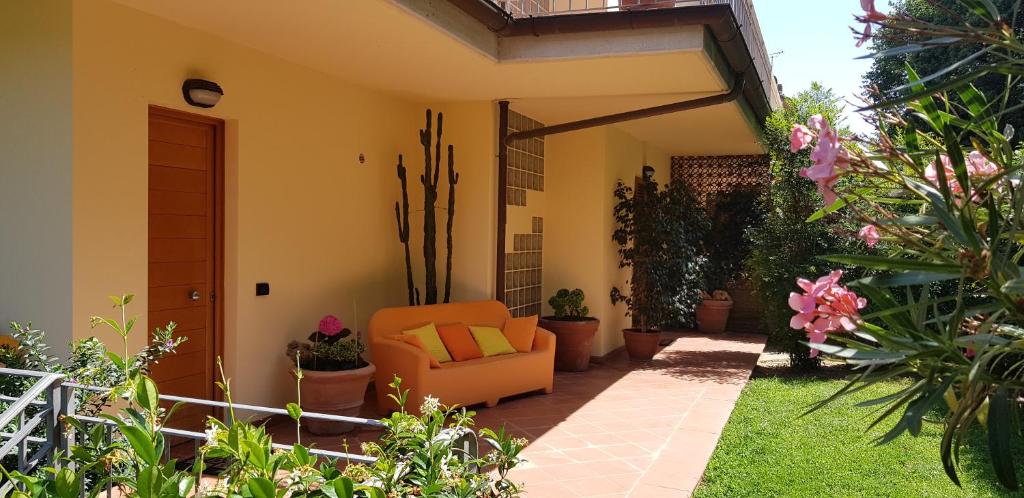 a patio with an orange chair in a garden at Casa Lia in Massarosa