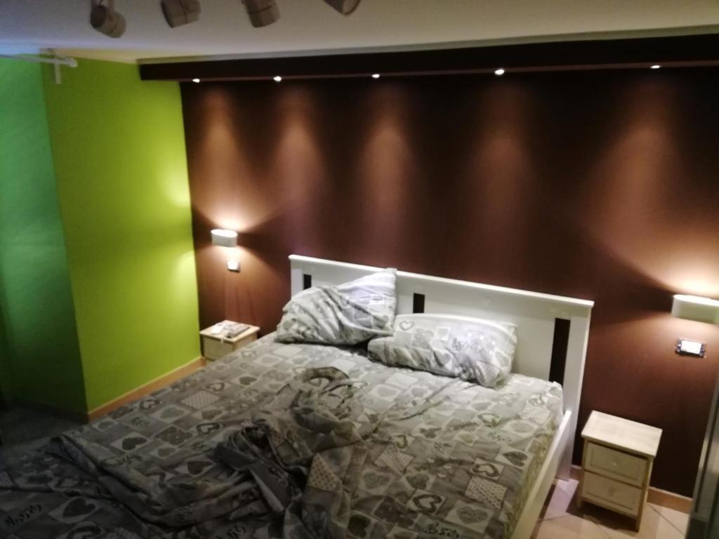 een slaapkamer met een bed met groene en bruine muren bij B&BProviter in Napels