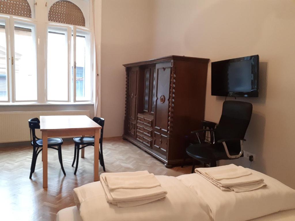 ブダペストにあるDob15 Big Apartmentのリビングルーム(テレビ、テーブル、椅子付)
