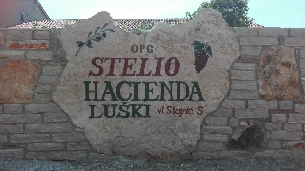 uma placa numa parede de tijolos que diz uma "siba hacienda justitz" em Apartment and Rooms Hacienda Stelio em Poreč