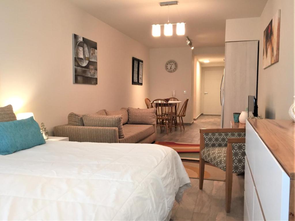 um quarto com uma cama e uma sala de estar em URBANA SUITES & STUDIOS 440 em San Carlos de Bariloche