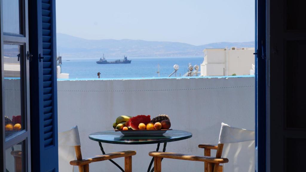 a table with a bowl of fruit on a balcony at Hotel Hara in Naxos Chora