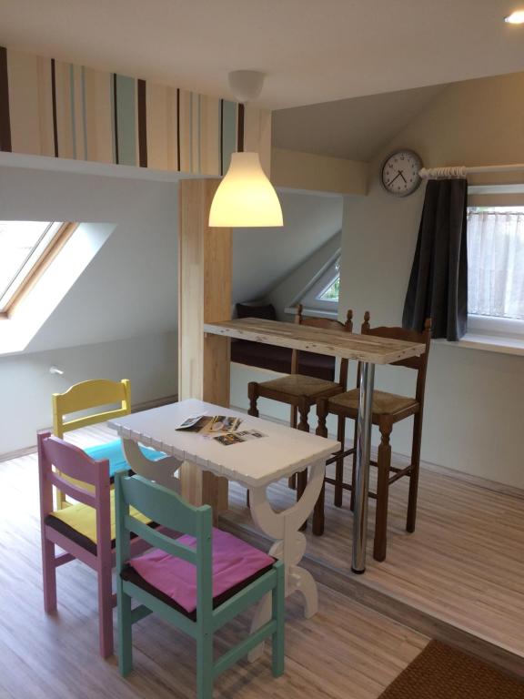 a kitchen and dining room with a table and chairs at Báró Berg Apartman in Kapuvár