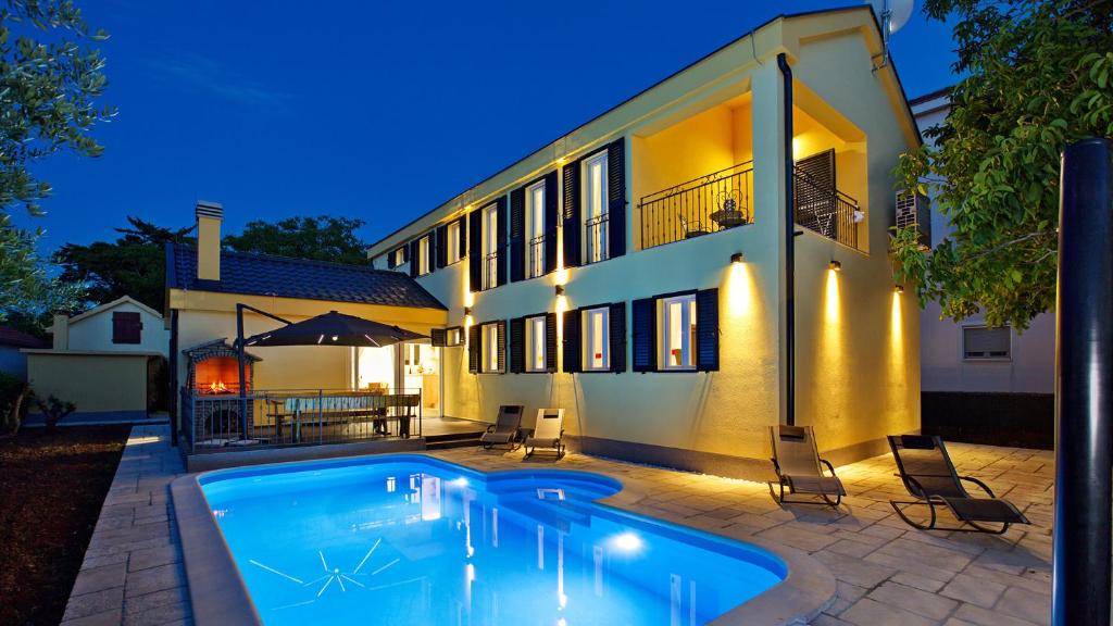 une maison avec une piscine en face de celle-ci dans l'établissement Villa Lorena, à Zaton