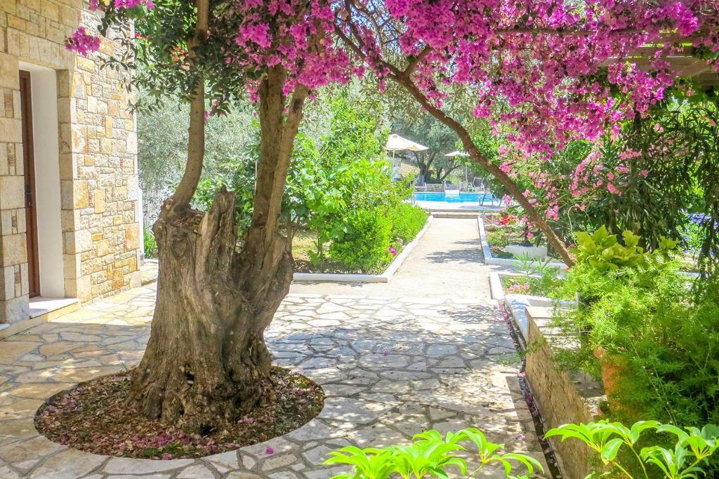 a tree with pink flowers on a sidewalk at Kerveli Luxury Villa in Kerveli