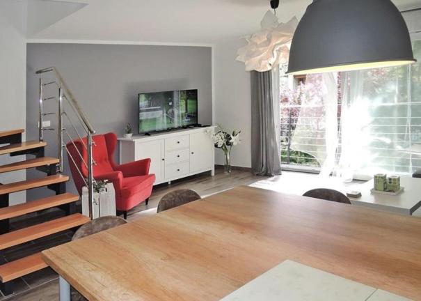ein Wohnzimmer mit einem Esstisch und einem TV in der Unterkunft Apartament Nr.9 in Pobierowo