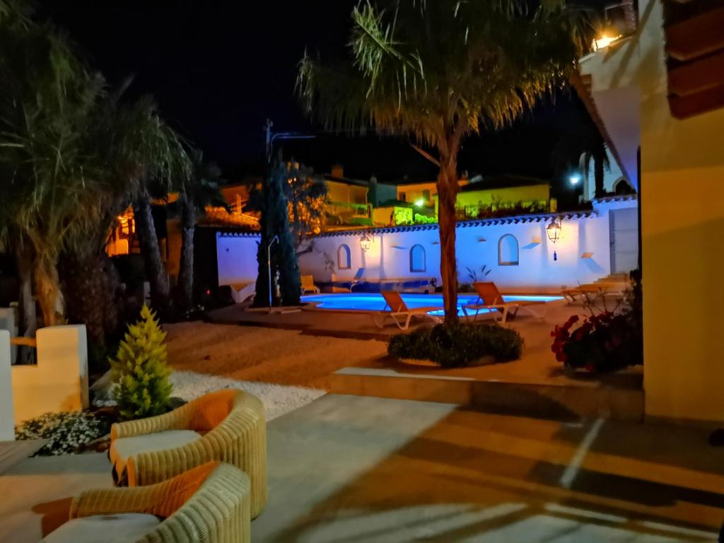 a resort at night with palm trees and chairs at Terrera Roberto in El Marchal
