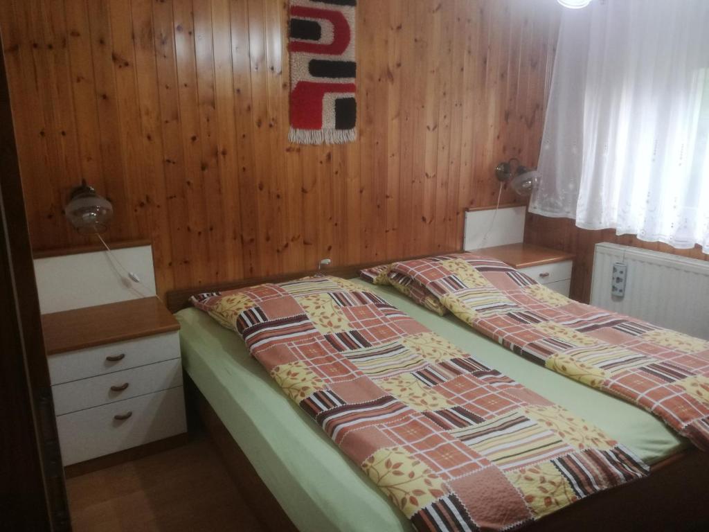 - une chambre avec 2 lits et un mur en bois dans l'établissement Apartma Vilma, à Kobarid