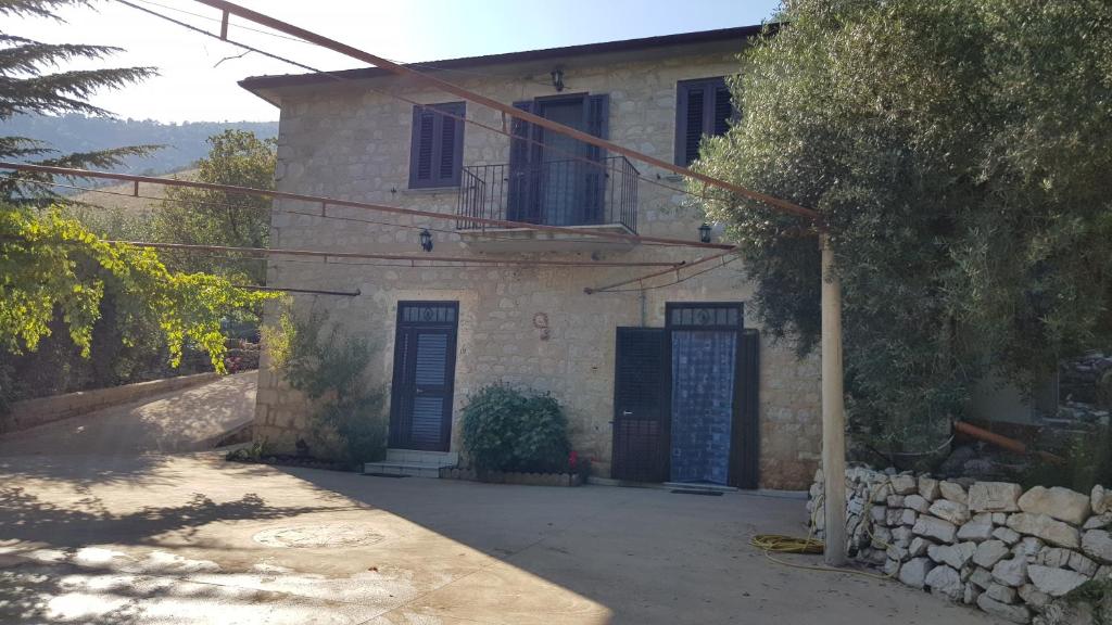 una casa con una puerta azul y una pared de piedra en villa del maestro, en Lenola