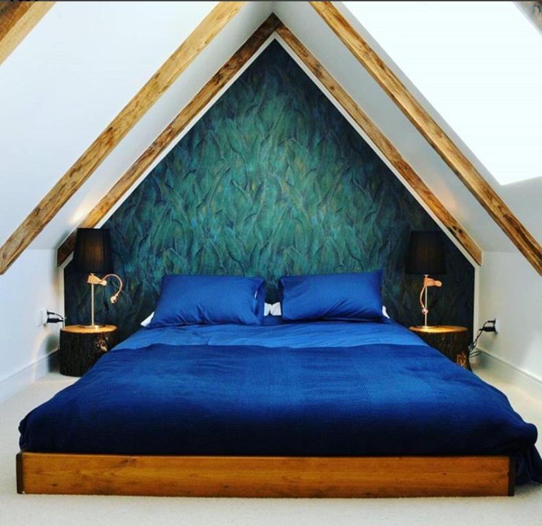 ザコパネにあるApartament Wokół Stołuの緑の壁のベッドルーム1室(青いベッド1台付)