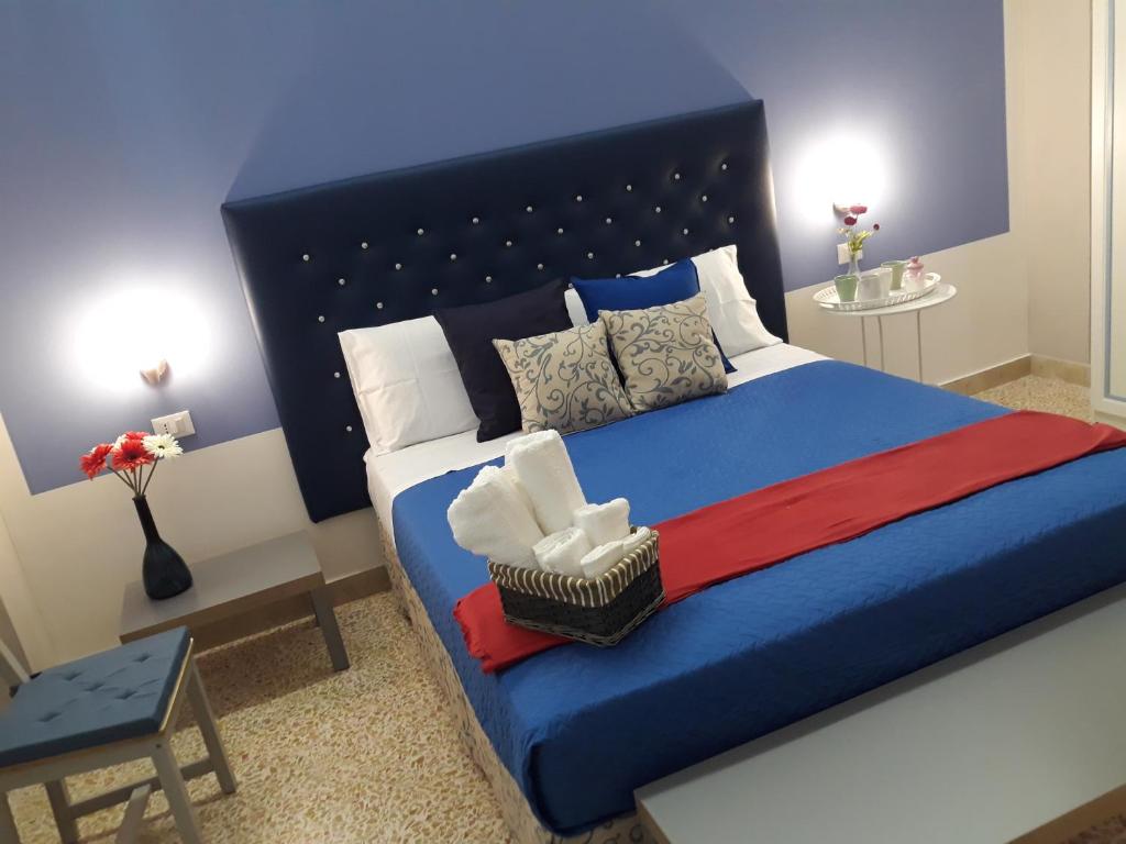 una camera da letto con un grande letto blu con testiera blu di 5 cupole a Palermo