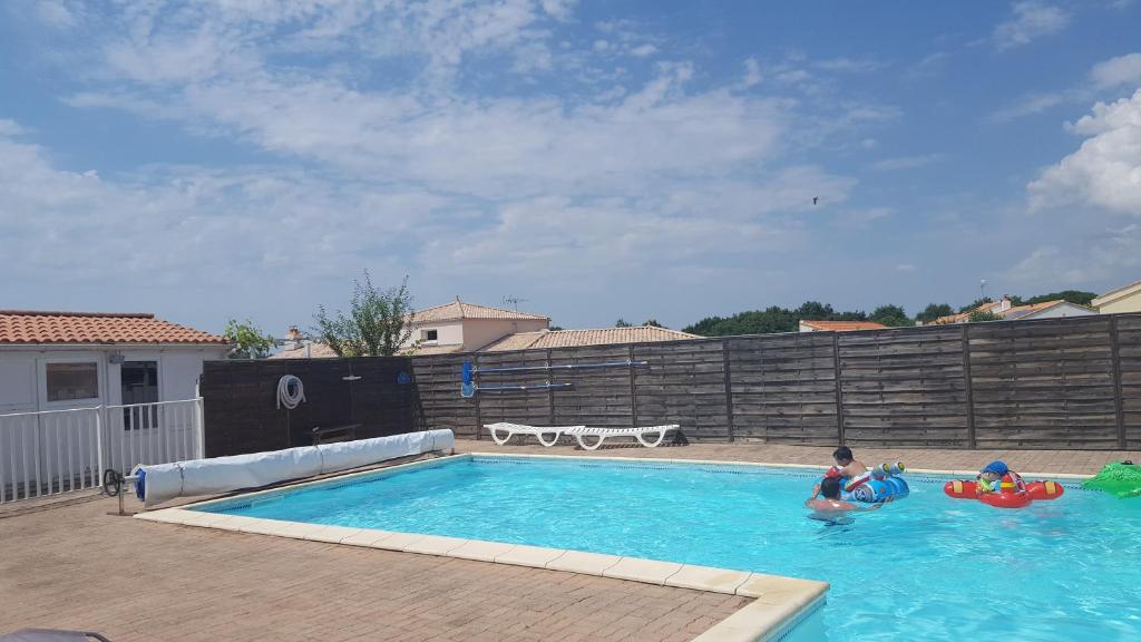 zwei Leute spielen in einem Schwimmbad in der Unterkunft Résidence la Joséphine in Les Sables-dʼOlonne