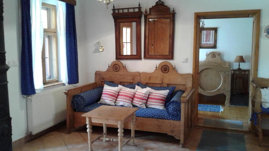 a room with a couch with pillows and a table at Nosztalgia Vendégház in Mezőkövesd