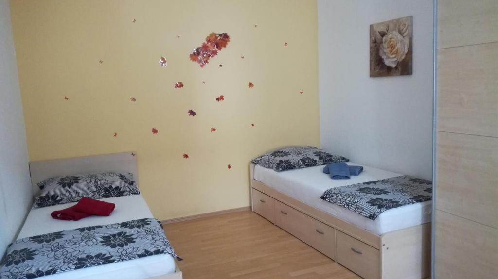 a bedroom with two beds and a wall with butterflies at Apartment Možina in Koper