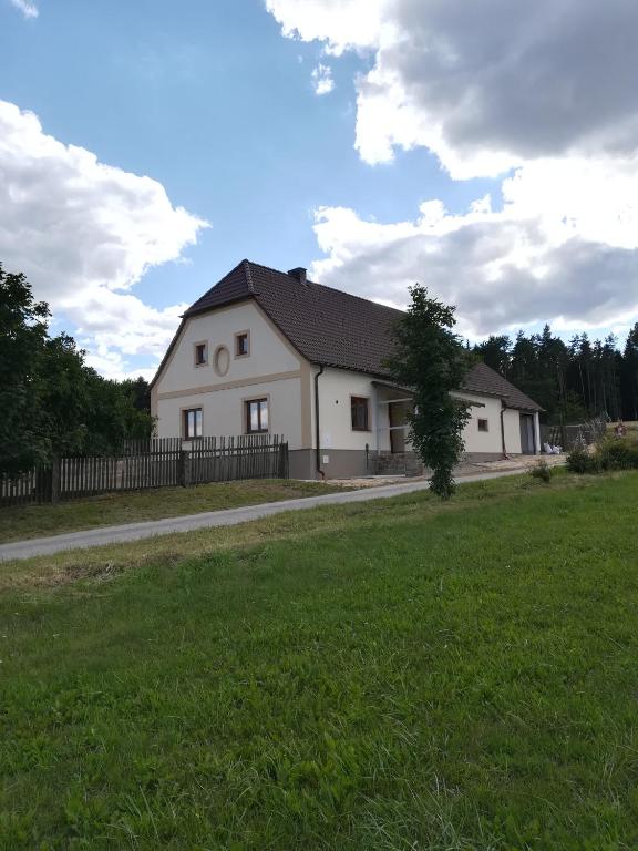 una casa bianca con recinzione e prato di Chalupa u lesa - Nova Ves a Český Rudolec
