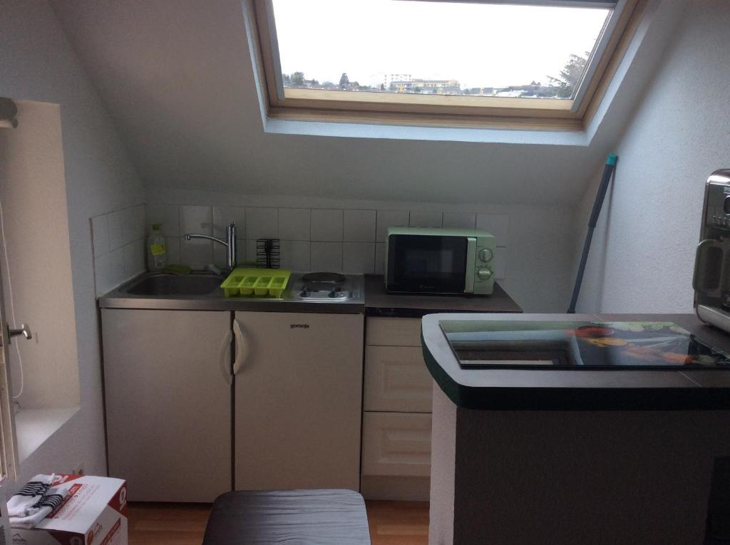 una pequeña cocina con fregadero y ventana en L&#39;appart de Clea, en Montluçon