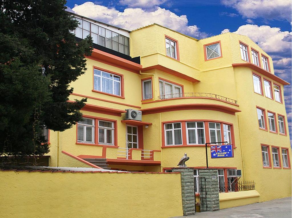żółty budynek z płotem przed nim w obiekcie Yellow Rose Pansiyon w mieście Çanakkale