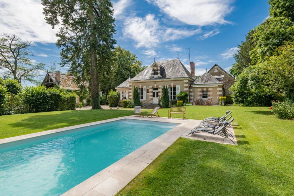 ショーモン・シュル・ロワールにあるAncien pavillon de chasse du château de Chaumont sur Loireの庭にスイミングプールがある家