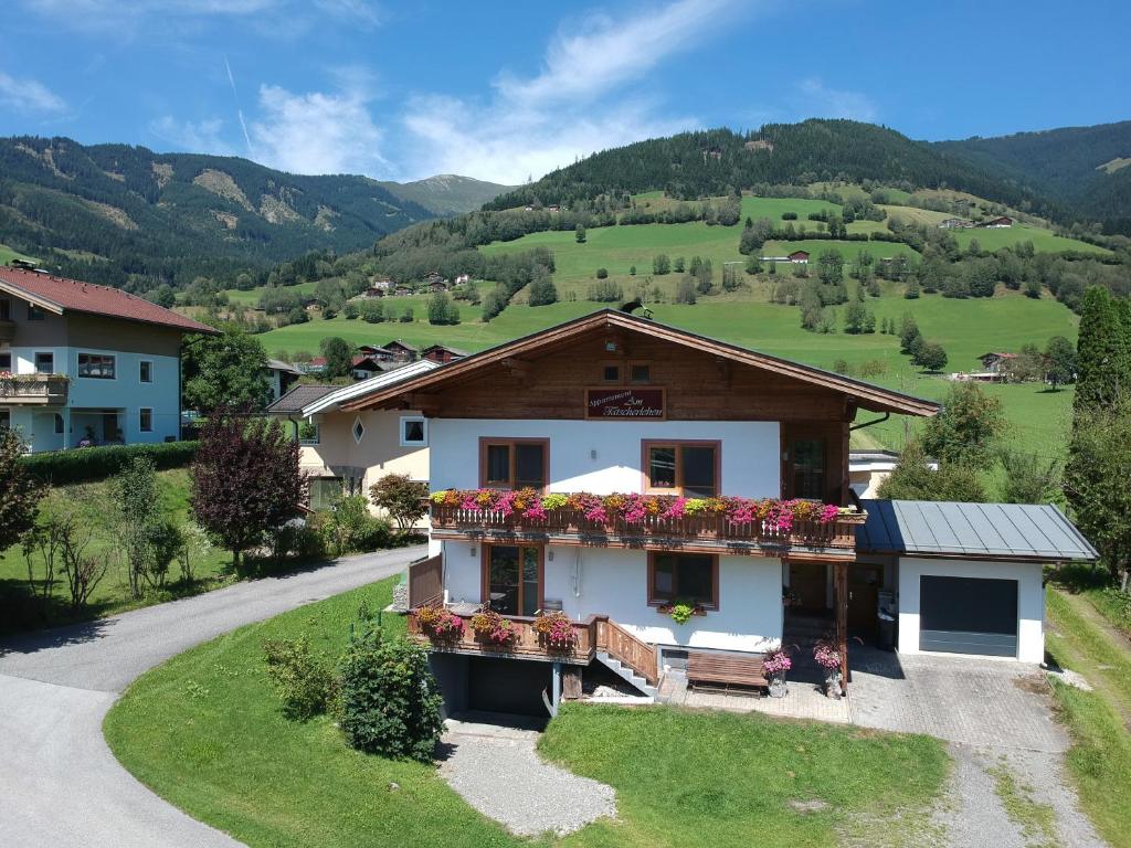 a building with flower boxes on the side of a road at Appartement Am Tatscherlehen in Piesendorf