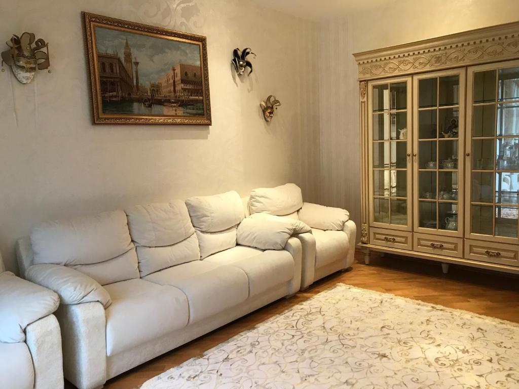 ein Wohnzimmer mit einem weißen Sofa und einem Gemälde in der Unterkunft Дворівневі Апартаменти Antique in Ternopil