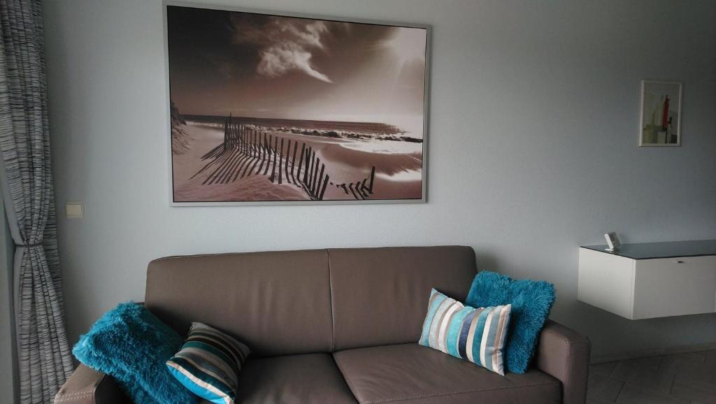 a living room with a couch and a picture on the wall at Apollo 90101 in Nieuwpoort