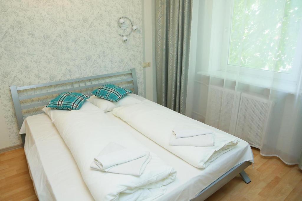 カリーニングラードにあるТрехкомнатная в историческом центреの白いベッド(枕2つ付)、窓が備わります。