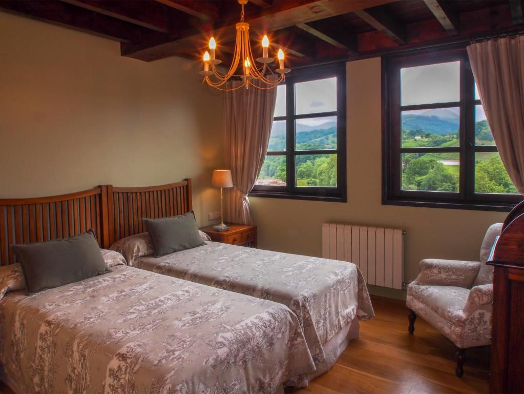 インフィエストにあるCasas Rurales Asturias Campon Antrialgoのベッドルーム1室(ベッド1台、椅子、窓付)