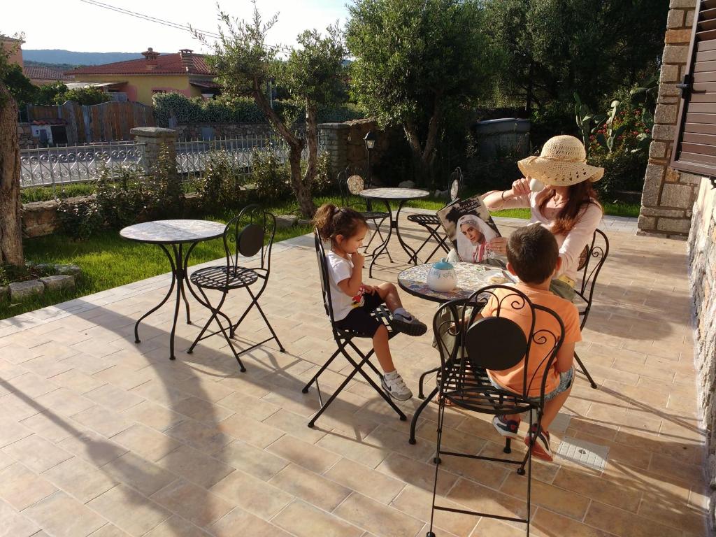 eine Gruppe von Menschen, die in einem Hof an Tischen sitzen in der Unterkunft B&B LE ISOLE in San Teodoro