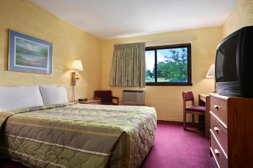 Una habitación de hotel con una cama y un televisor de pantalla plana. en Motel 6-Eau Claire, WI, en Eau Claire