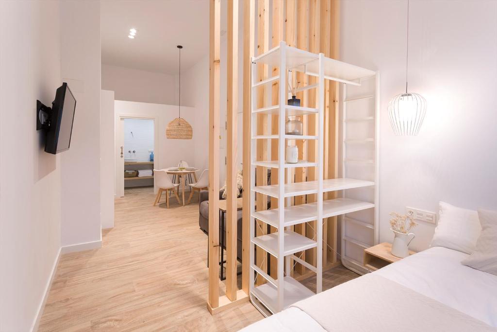 a bedroom with a white spiral book shelf next to a bed at GETARIA APARTAMENTUAK - Sahatsaga in Getaria