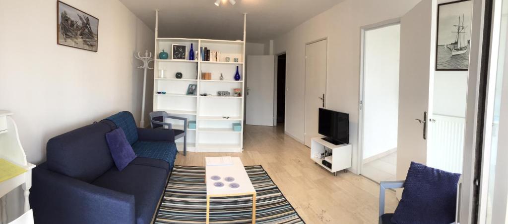 un salon avec un canapé bleu et une télévision dans l'établissement Natalilocs, au Golfe-Juan