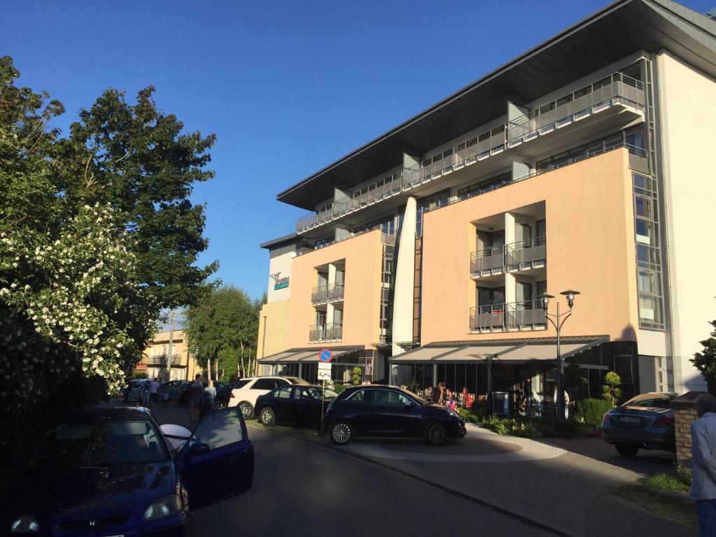 une rue avec des voitures garées devant un bâtiment dans l'établissement Atrium Apartament, à Sarbinowo