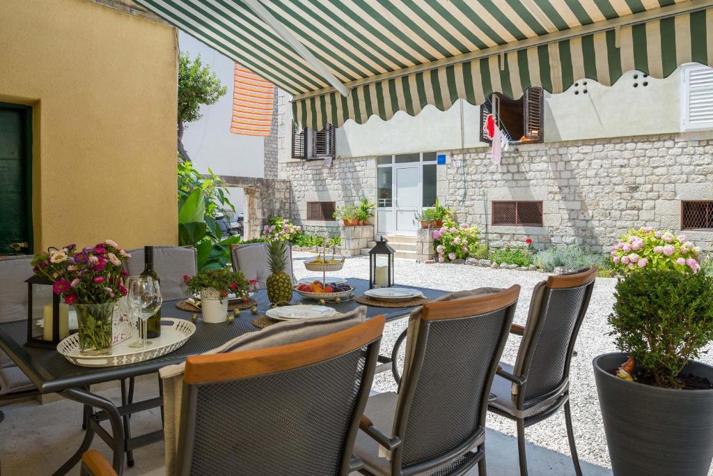 un patio con mesa y sillas y un edificio en Apartment Pere en Trogir