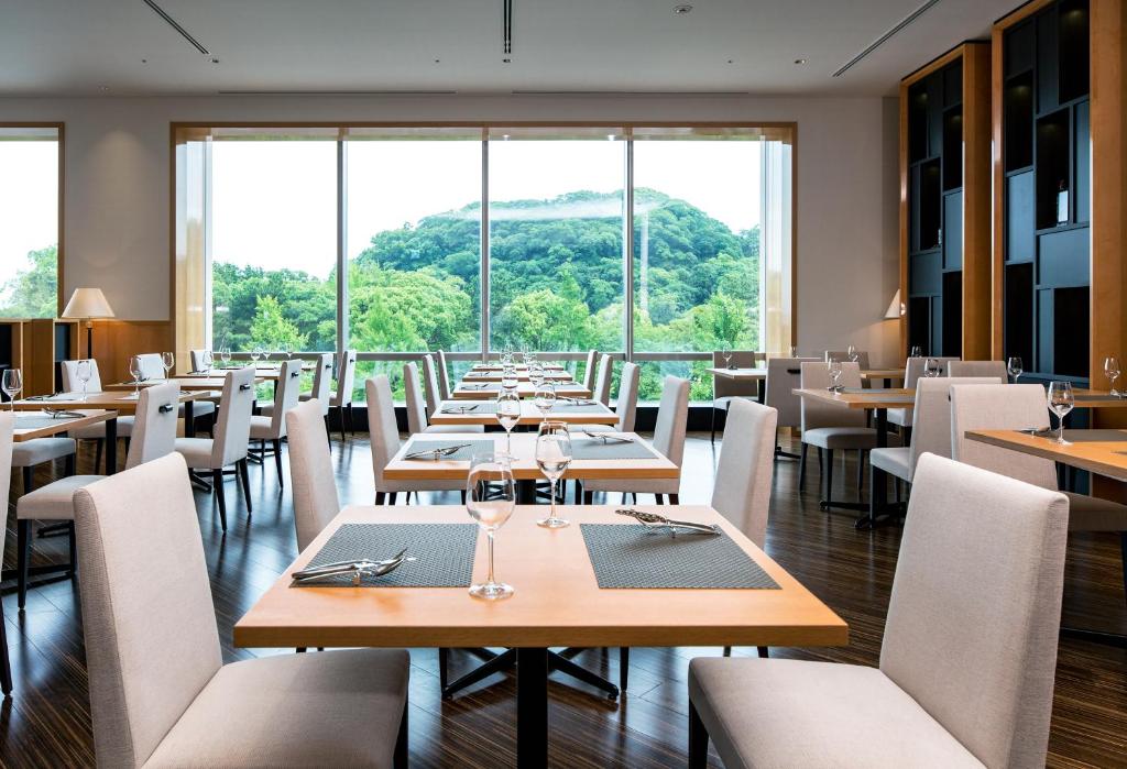 a restaurant with tables and chairs in it at Daiwa Roynet Hotel Wakayama in Wakayama
