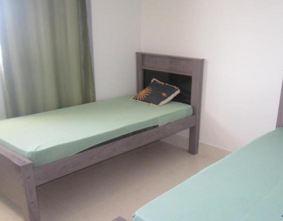 una cama de madera con una almohada en la habitación en Apartamento a 200 m da Praia do Morro, en Guarapari