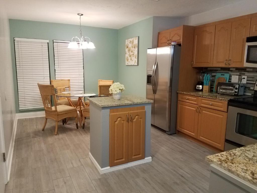 a kitchen and dining room with a table and refrigerator at 2BR/1BA Vacation Rental - Sienna Park in Sarasota
