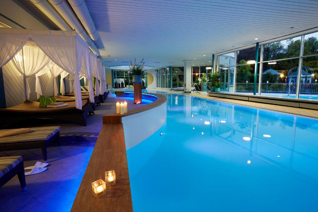 a pool with a bar in a hotel at Göbel's Hotel AquaVita in Bad Wildungen