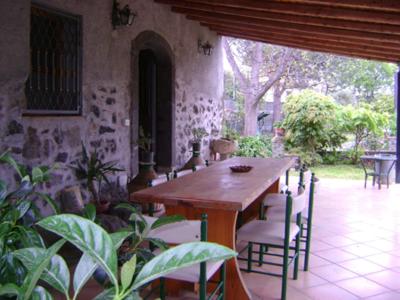 a wooden table and chairs in a room at Studio Apartment with garden and free parking in Giardini Naxos