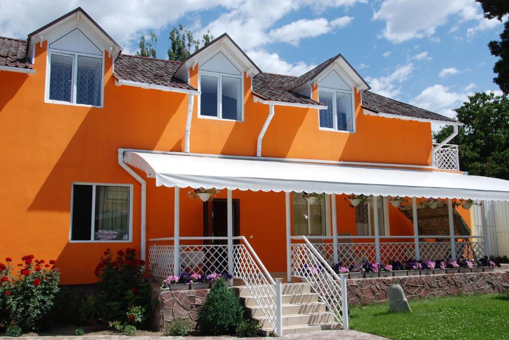 an orange house with a white awning at Osobyi Guest house in Cholpon-Ata