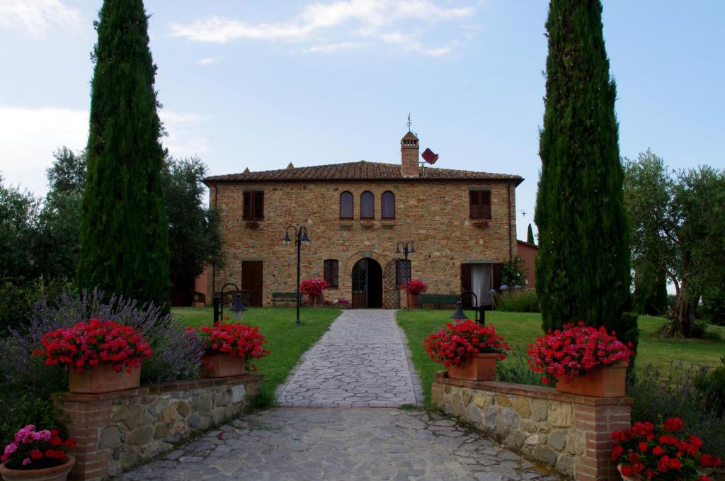 un viejo edificio de piedra con flores delante en Agriturismo I Romiti, en Castiglione del Lago